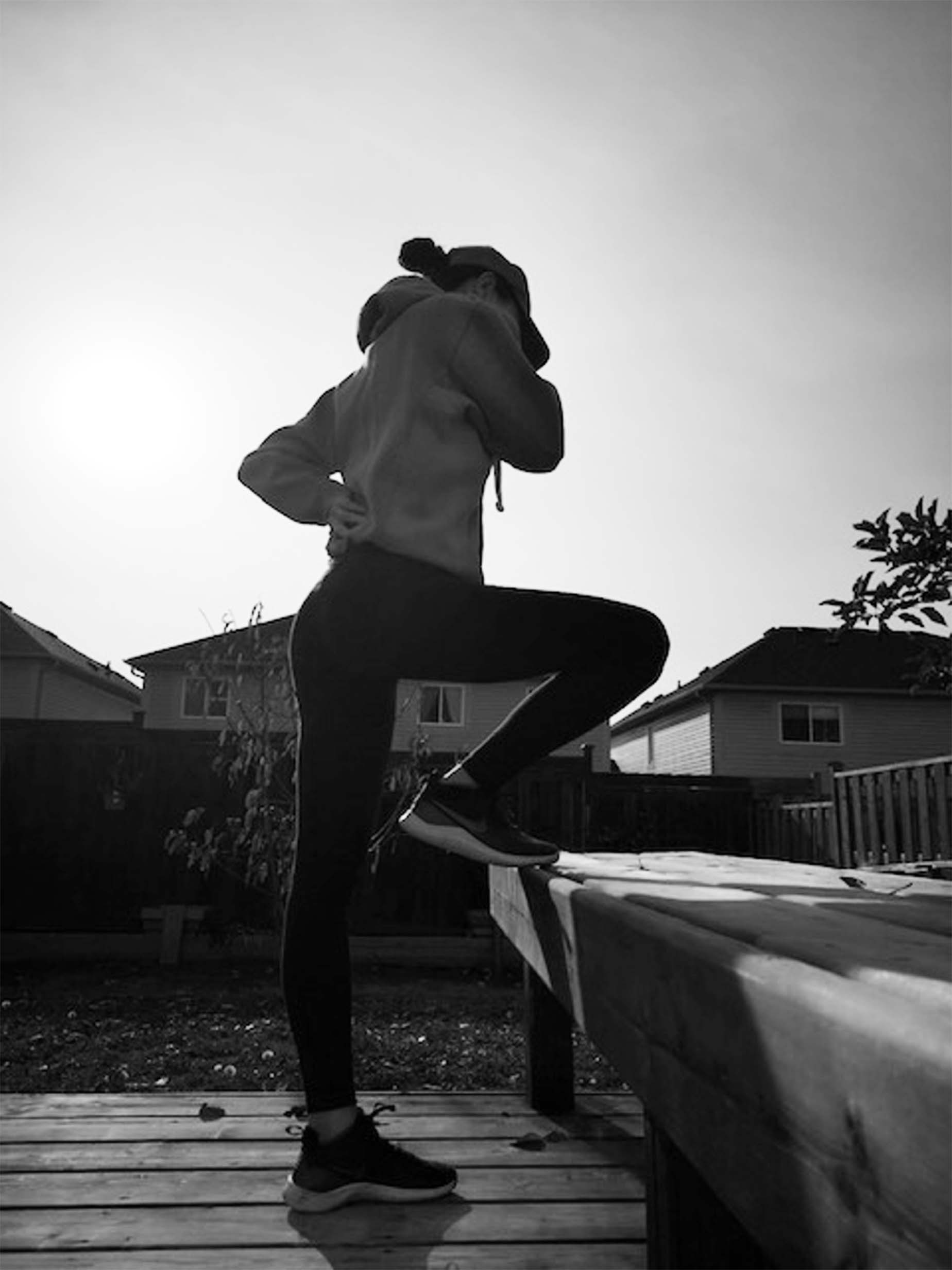 Woman getting ready for a jog. One leg raised and bent
